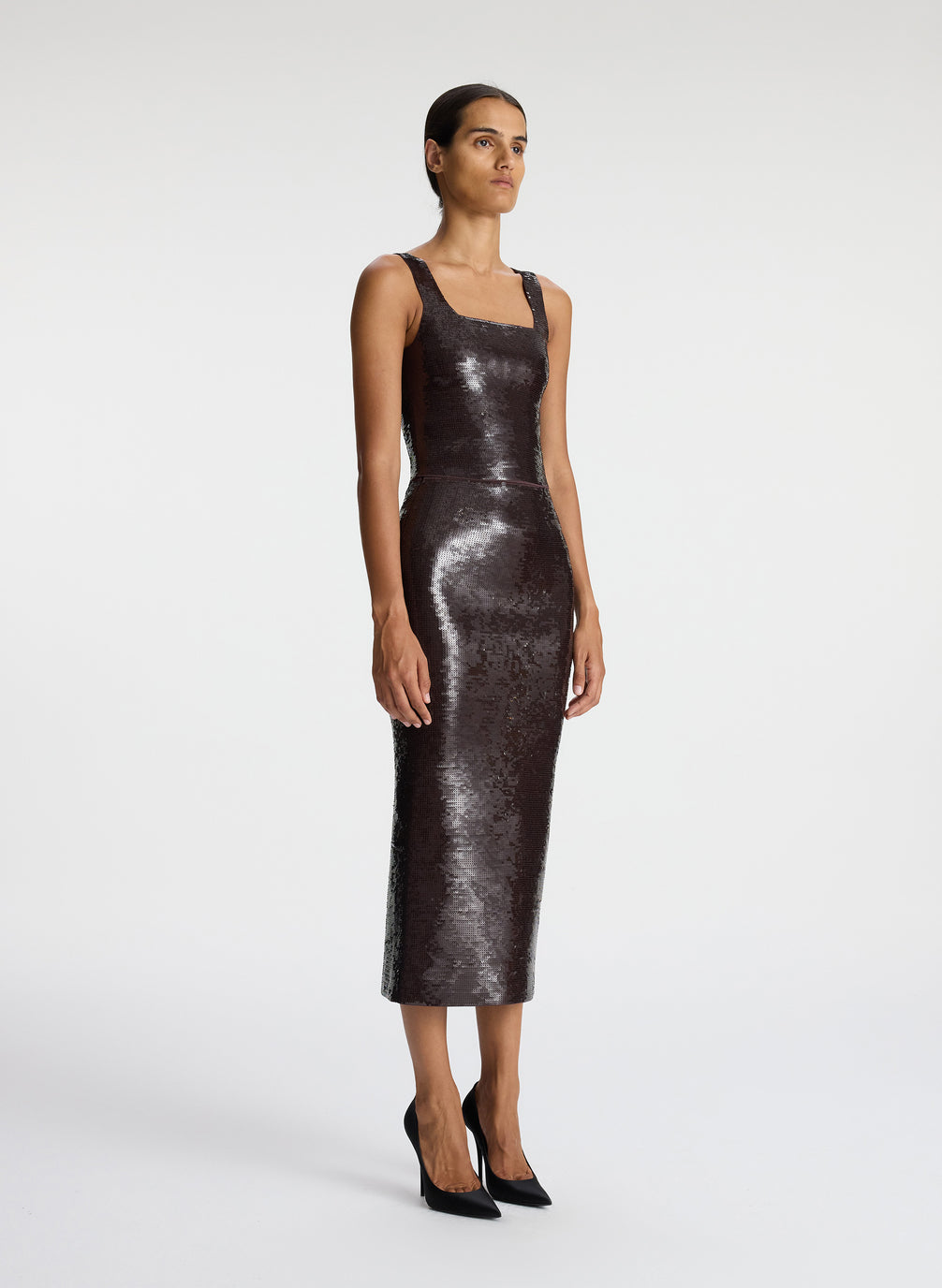 side view of woman wearing brown sequined sleeveless top and matching brown sequined midi skirt