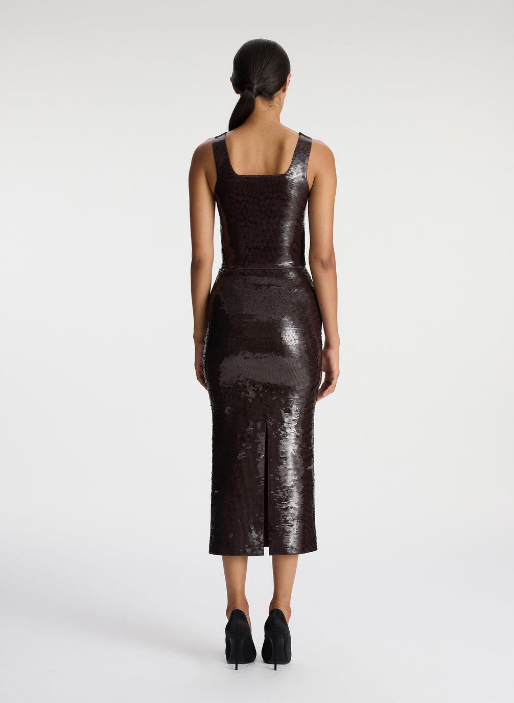 back view of woman wearing brown sequined sleeveless top and matching brown sequined midi skirt