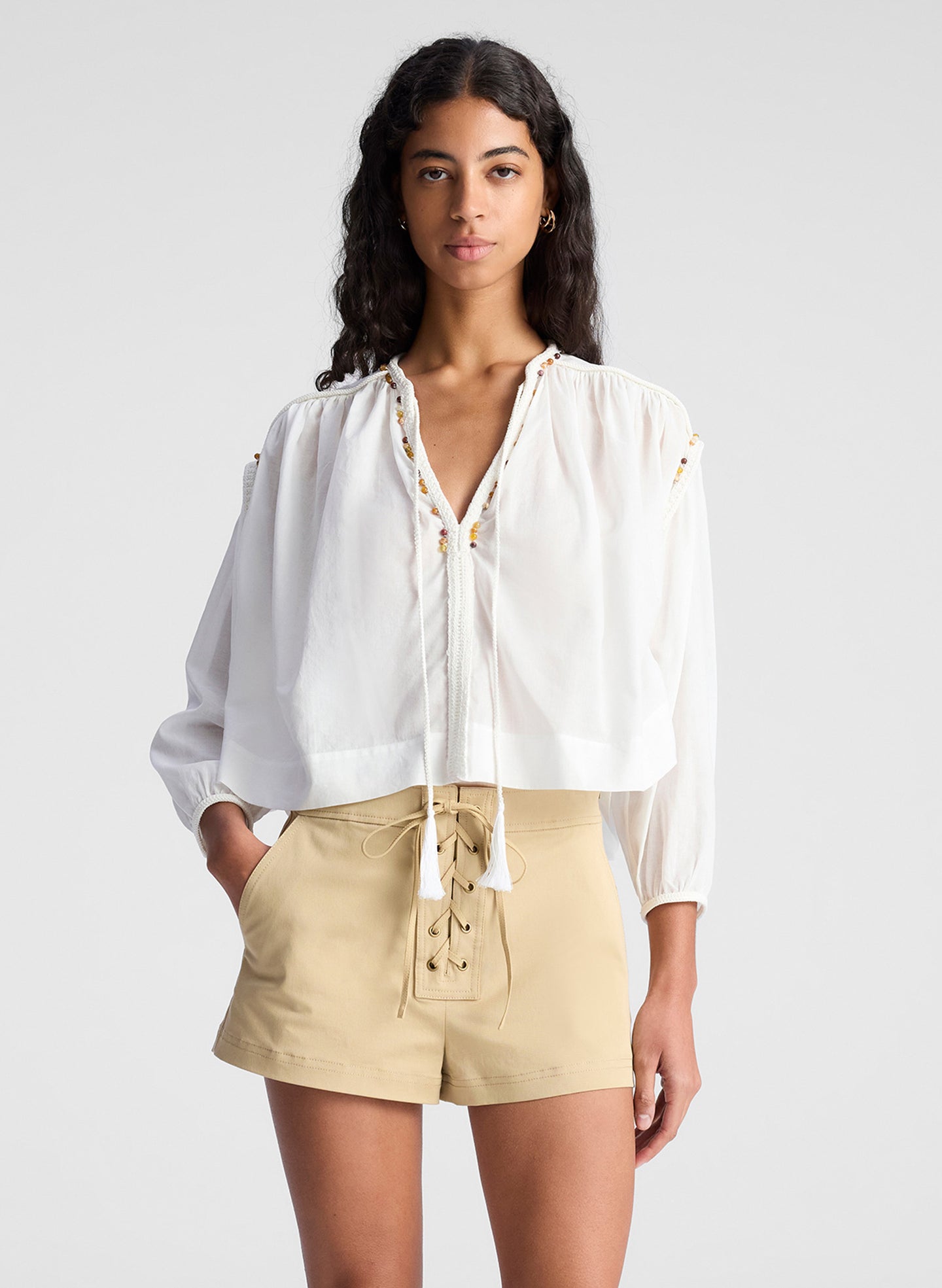 woman wearing white blouse and beige lace up detail short
