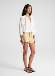 woman wearing white blouse and beige lace up detail short