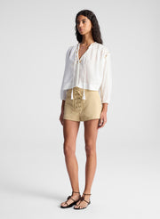 woman wearing white blouse and beige lace up detail short
