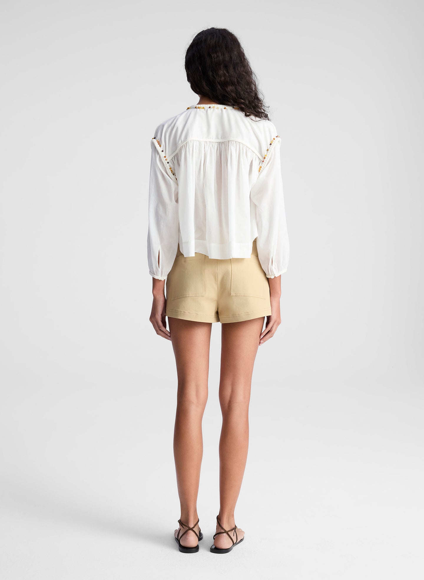 woman wearing white blouse and beige lace up detail short