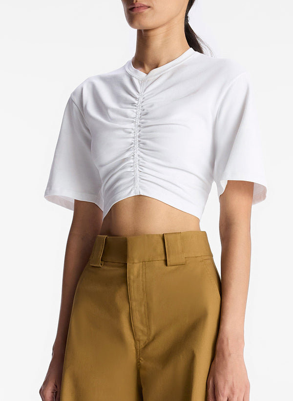 detail view of woman wearing white tshirt with center ruching and tan cargo pants