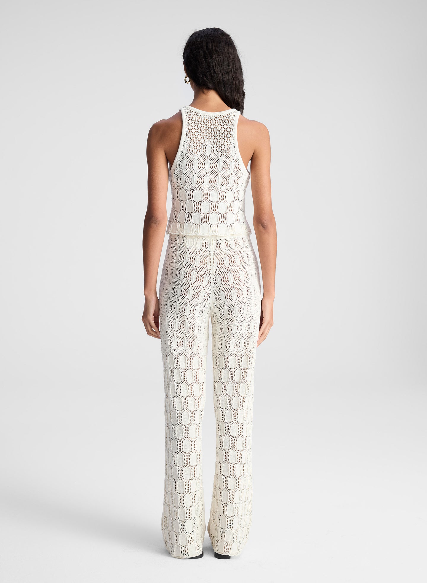 woman wearing white open knit tank top and matching set pants