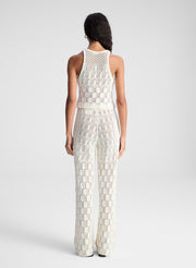 woman wearing white open knit tank top and matching set pants