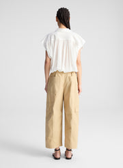 woman wearing white shirt and beige pants