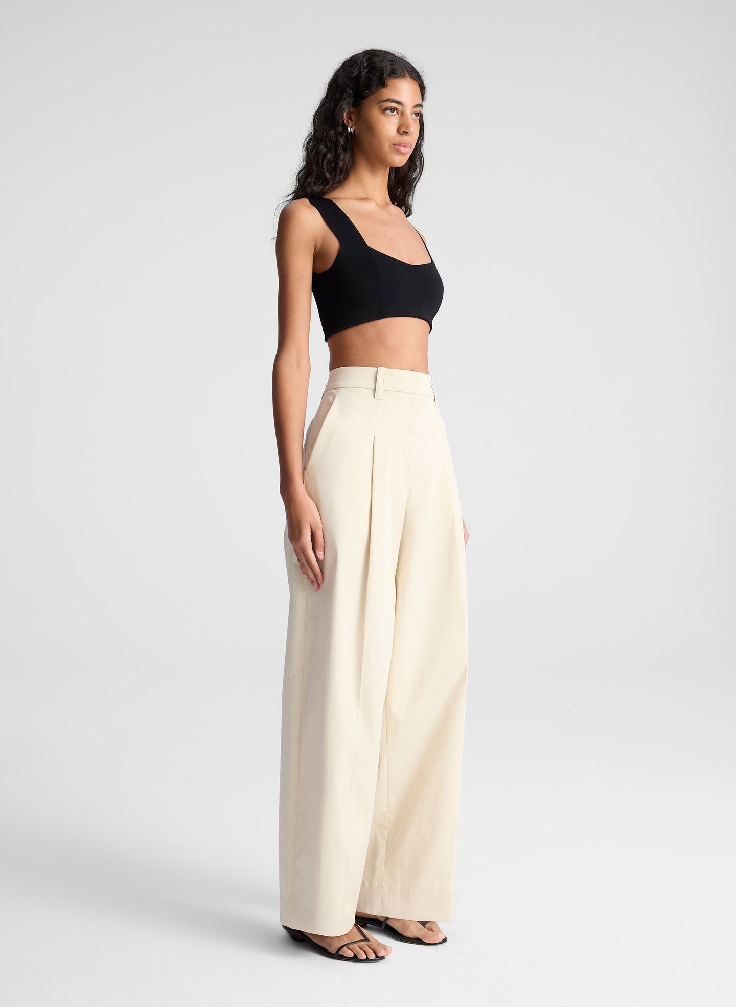 woman wearing black bra top and beige pants