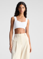 woman wearing white bra top and beige pants