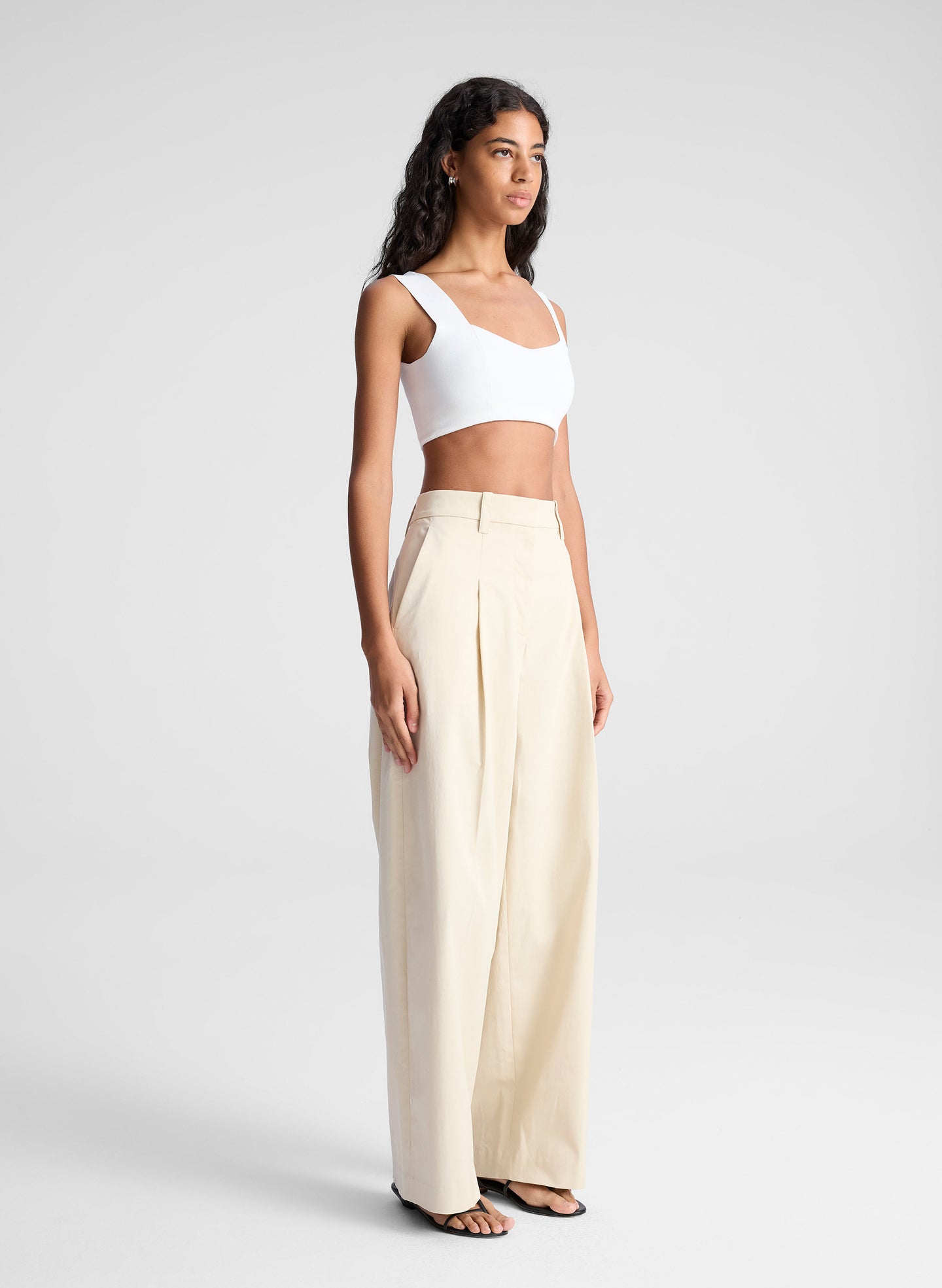 woman wearing white bra top and beige pants