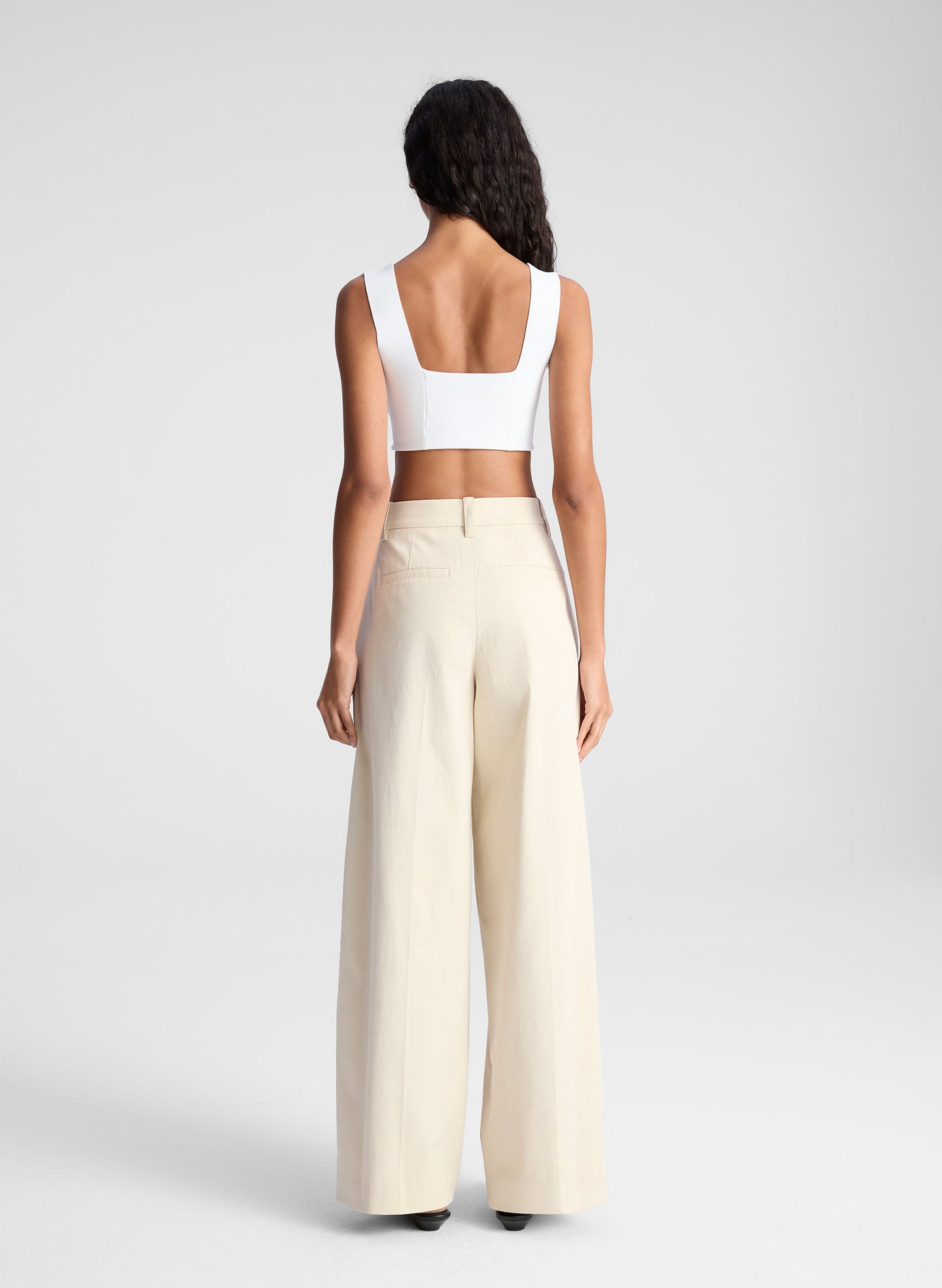 woman wearing white bra top and beige pants