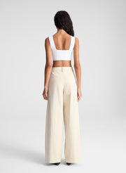 woman wearing white bra top and beige pants