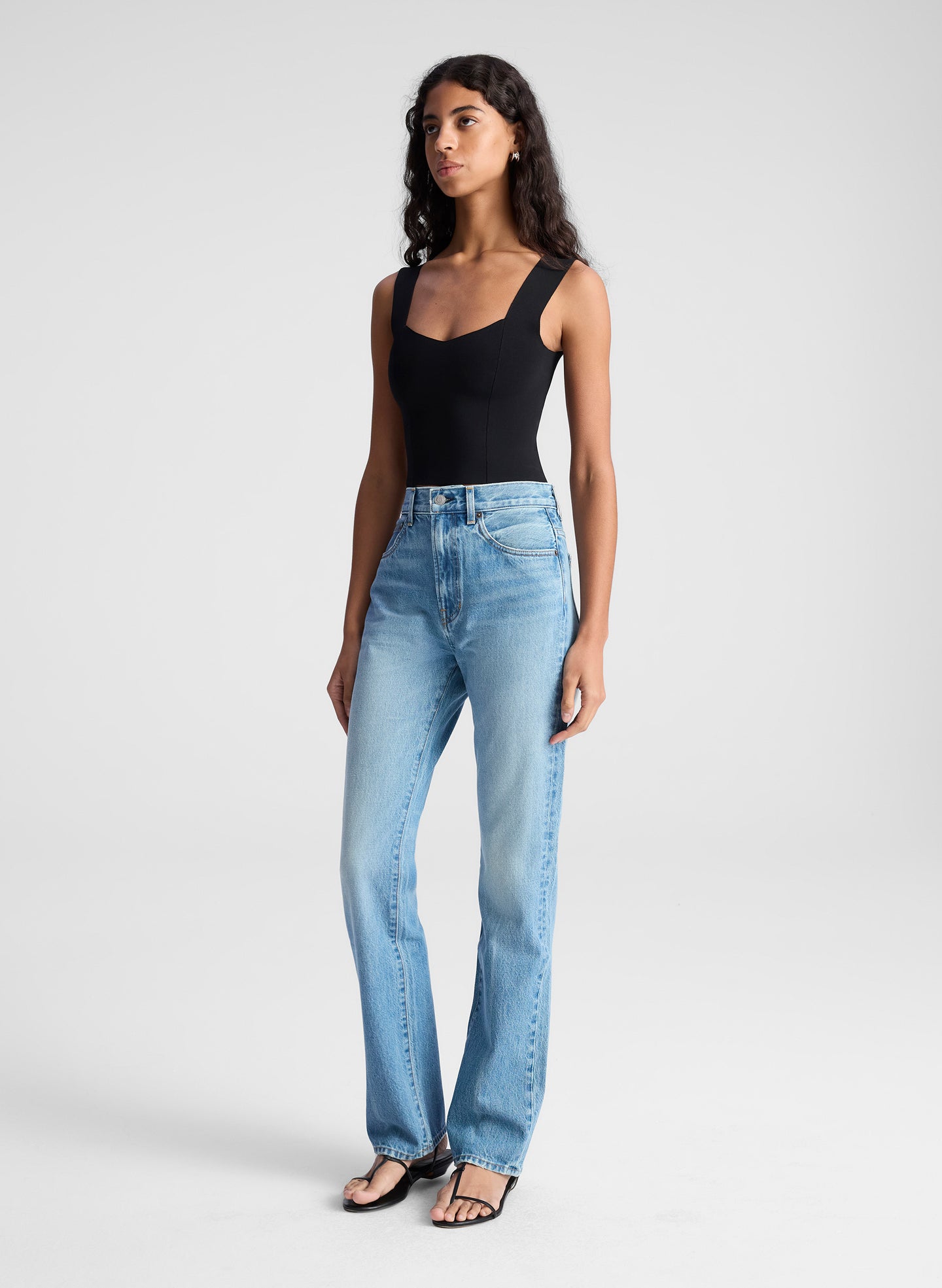 woman wearing black tank top and blue denim