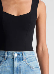 woman wearing black tank top and blue denim