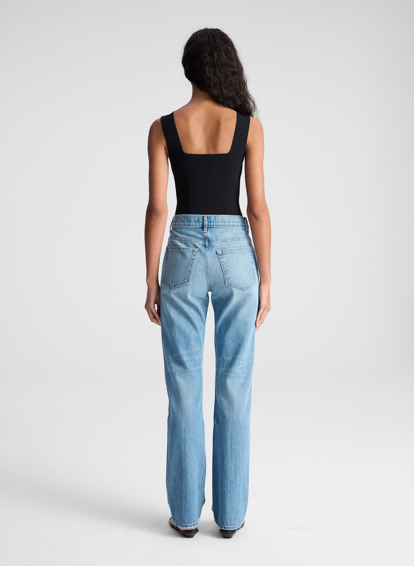 woman wearing black tank top and blue denim