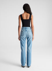 woman wearing black tank top and blue denim