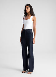 woman wearing white sleeveless top and navy blue pants