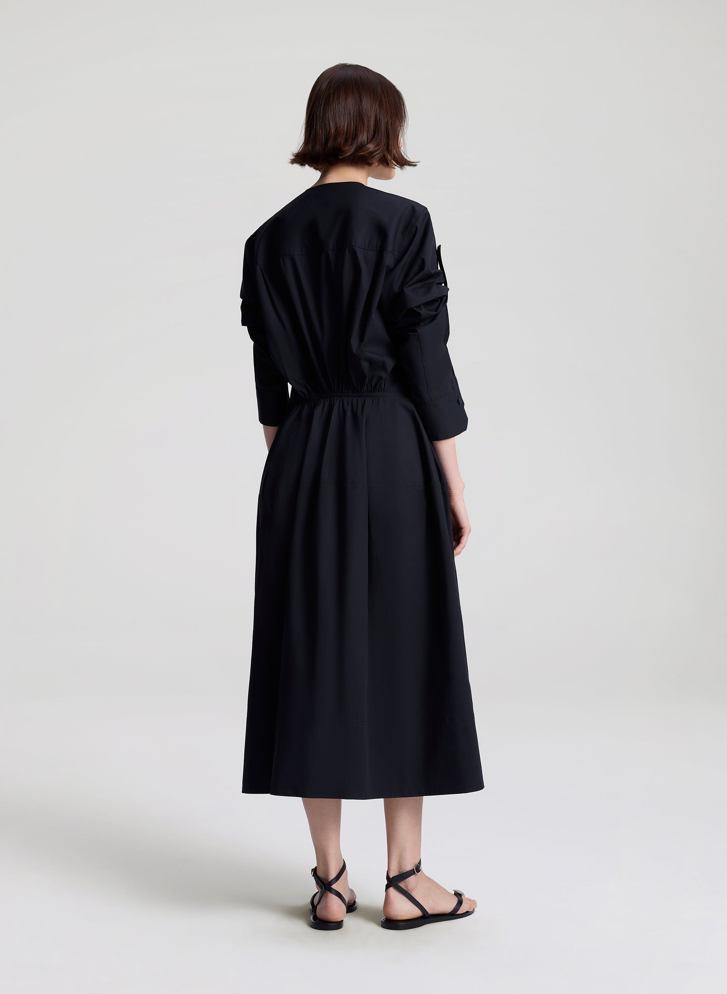 Person wearing a black dress on a white background