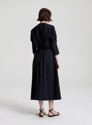 Person wearing a black dress on a white background