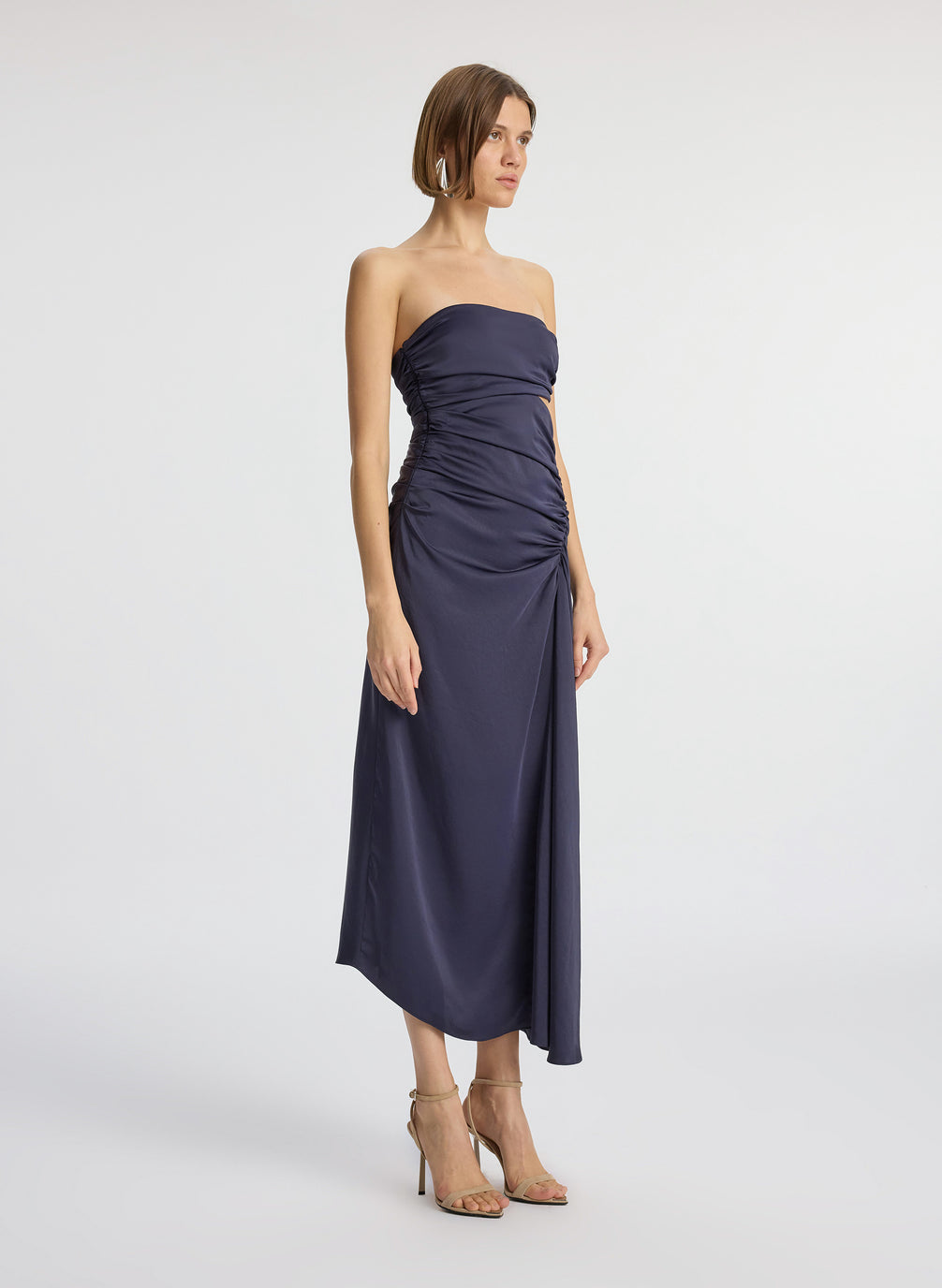 side view of woman wearing navy blue strapless midi dress