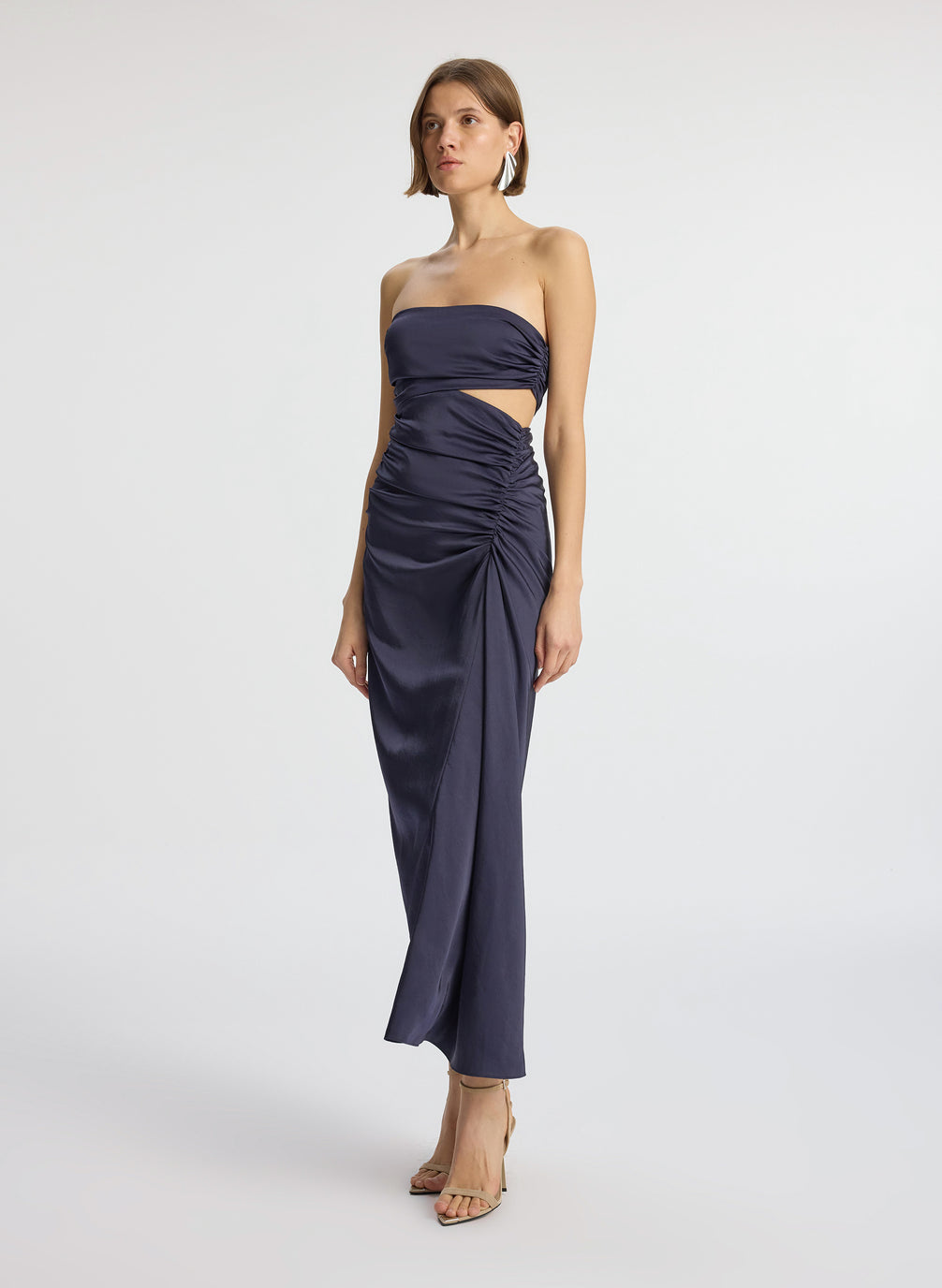 side view of woman wearing navy blue strapless midi dress