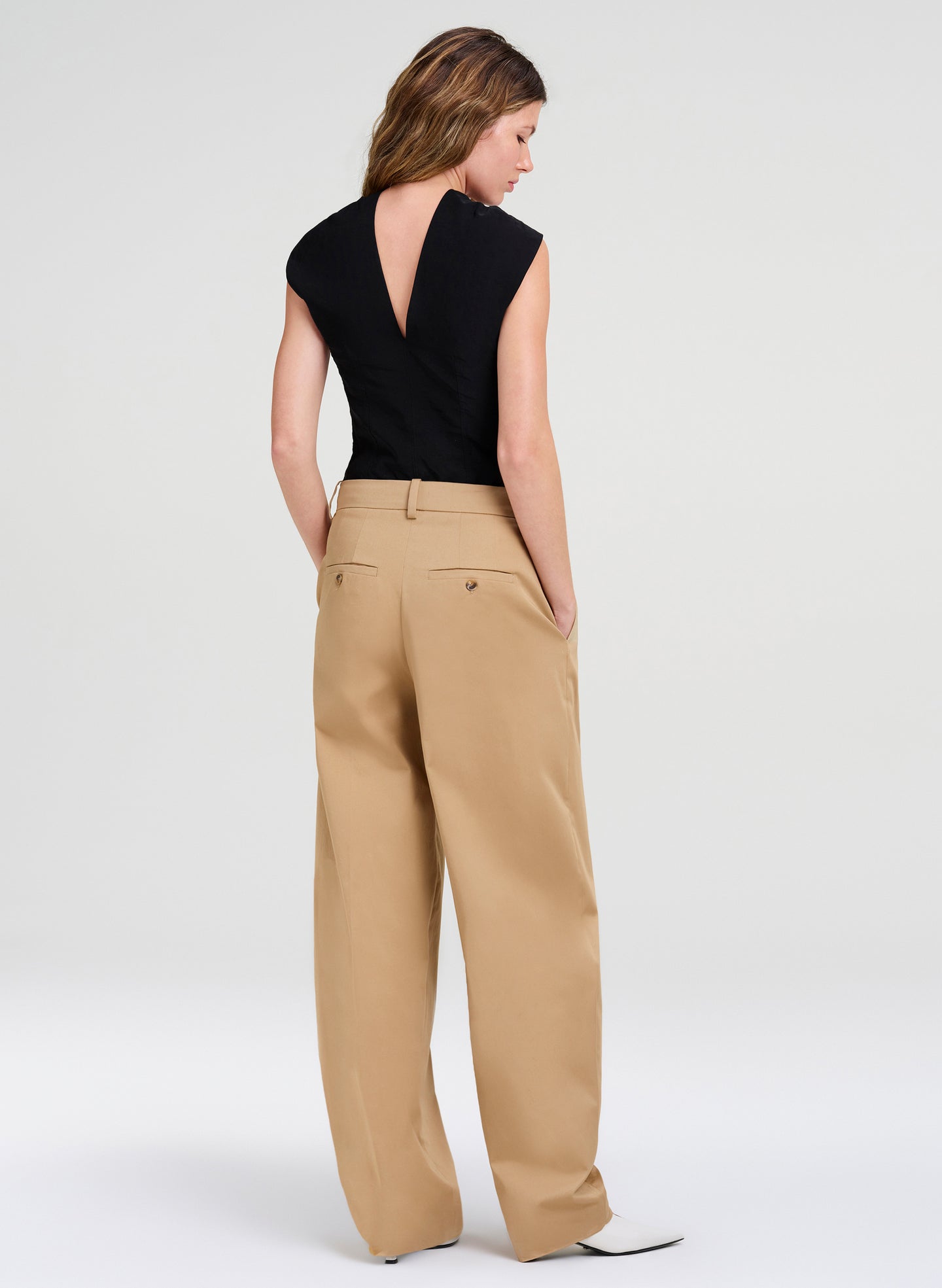 woman in black top and tan pants