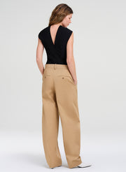 woman in black top and tan pants