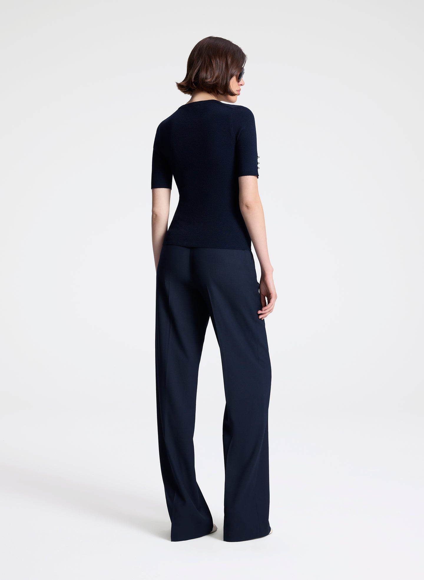 Person wearing a navy outfit on a white background