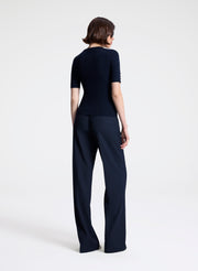 Person wearing a navy outfit on a white background