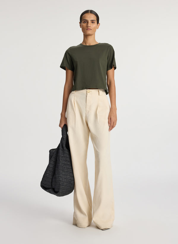 front view of woman wearing olive green short sleeve tshirt and beige wide leg pants