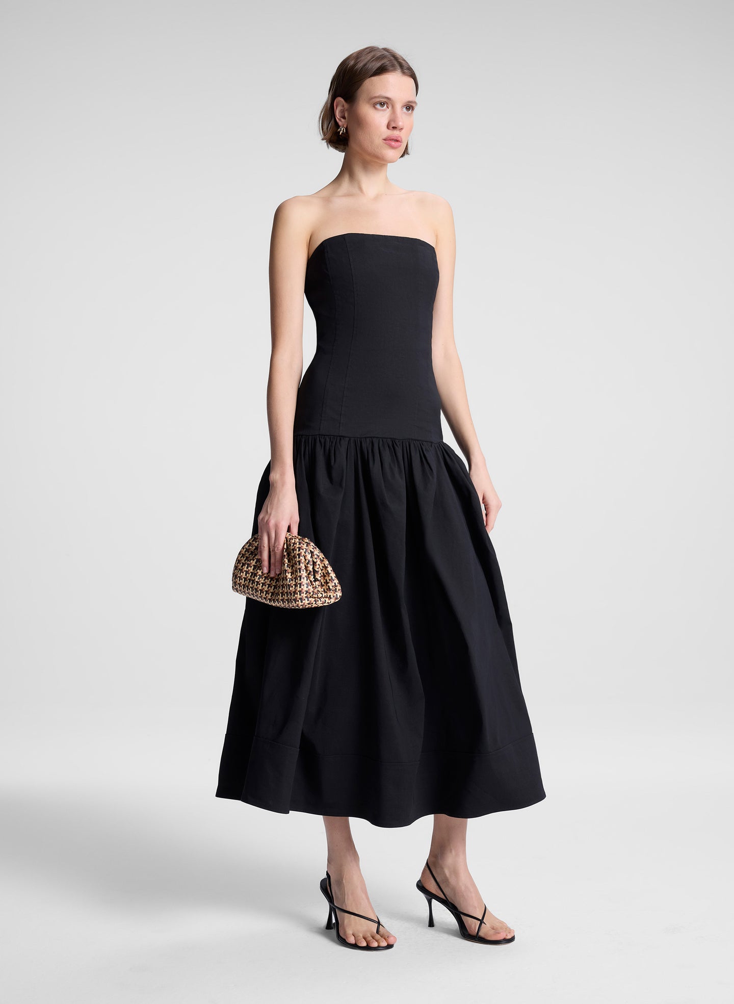 woman wearing black strapless drop waist midi dress