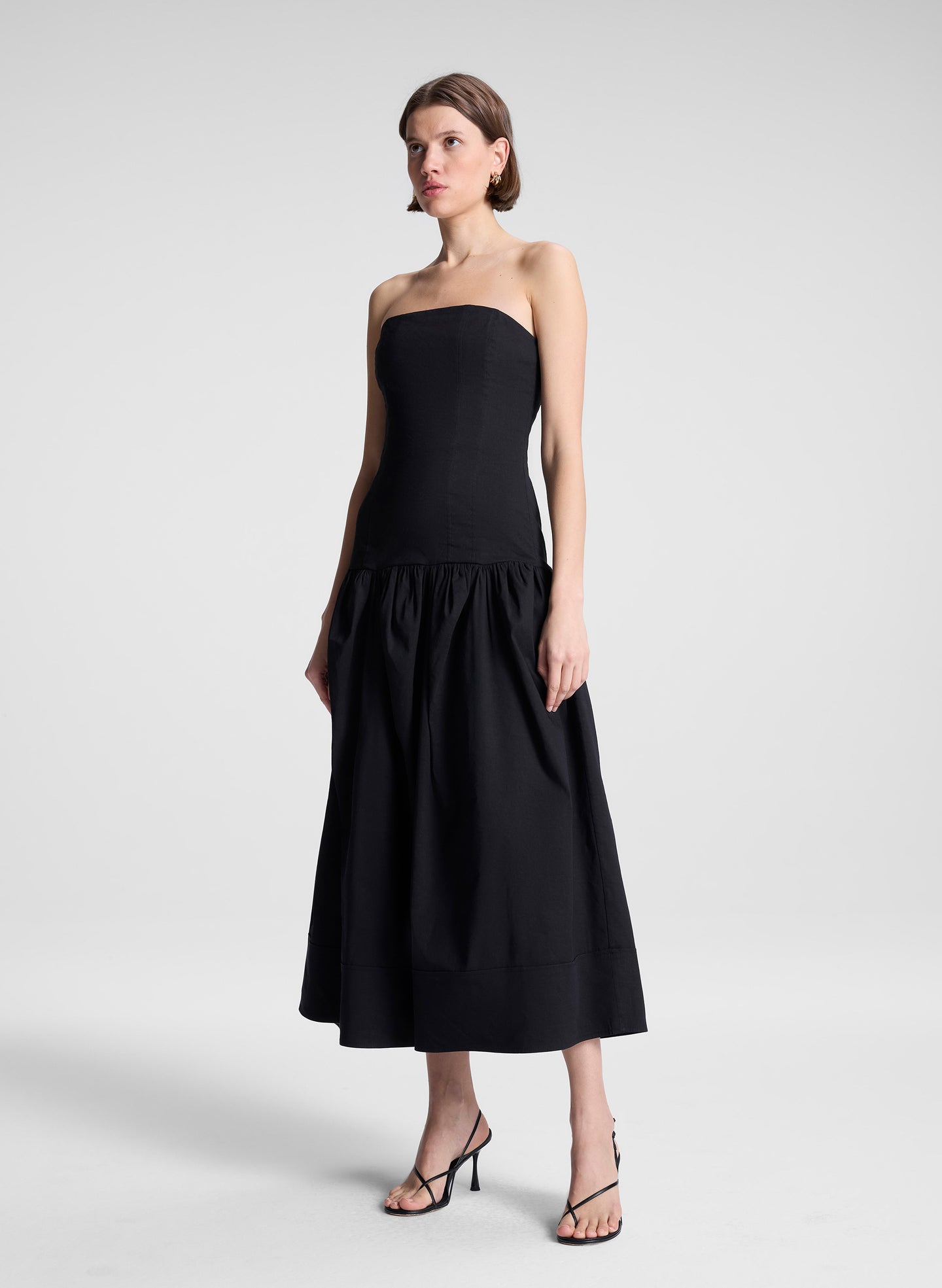 woman wearing black strapless drop waist midi dress