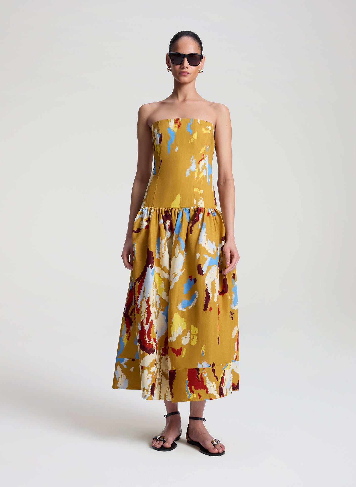woman wearing yellow printed strapless midi dress