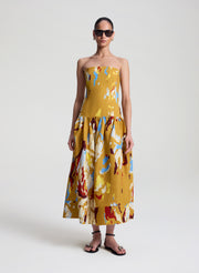 woman wearing yellow printed strapless midi dress