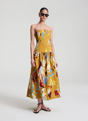 woman wearing yellow printed strapless midi dress