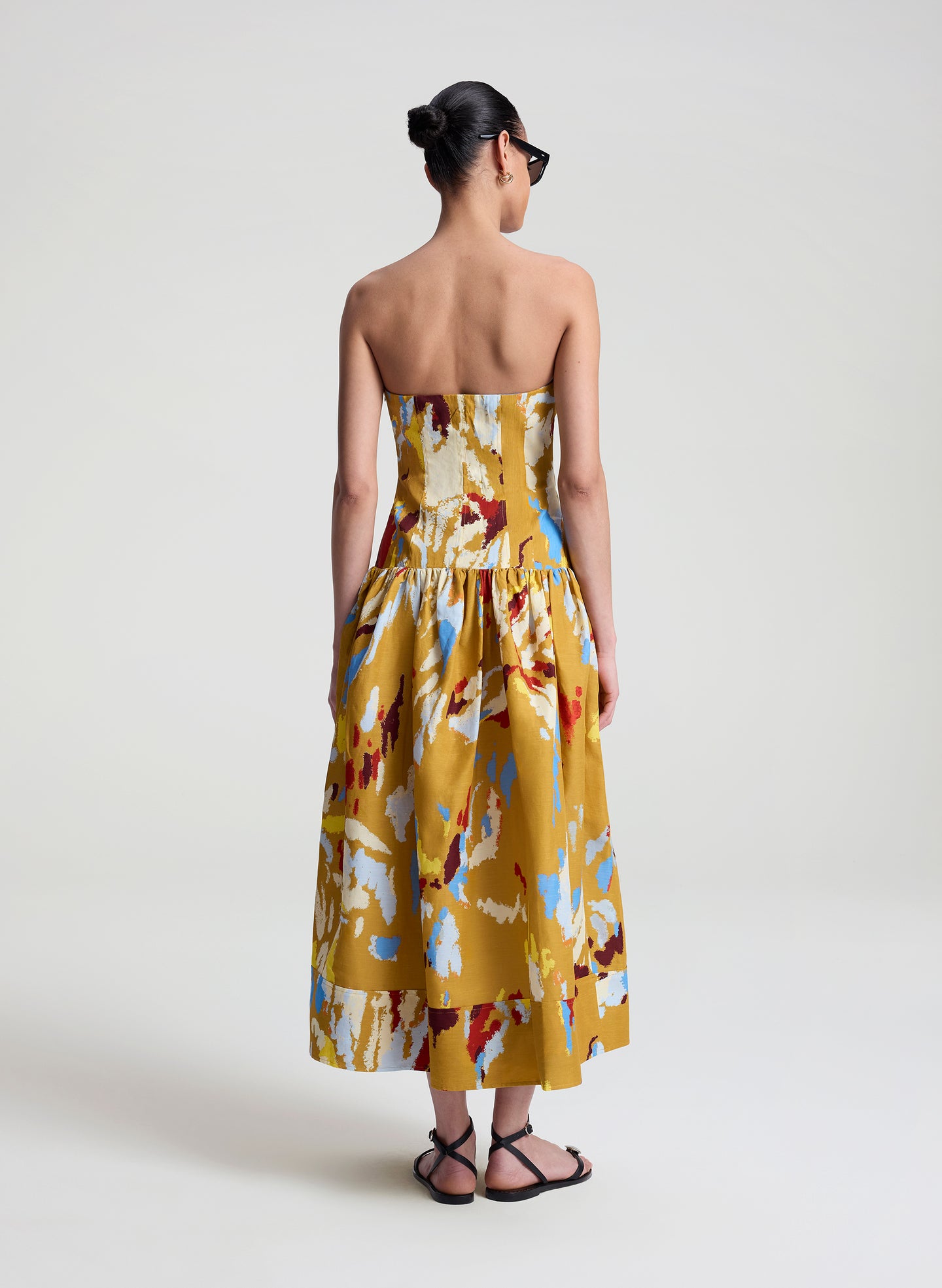 woman wearing yellow printed strapless midi dress