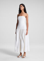 woman wearing white strapless drop waist midi dress