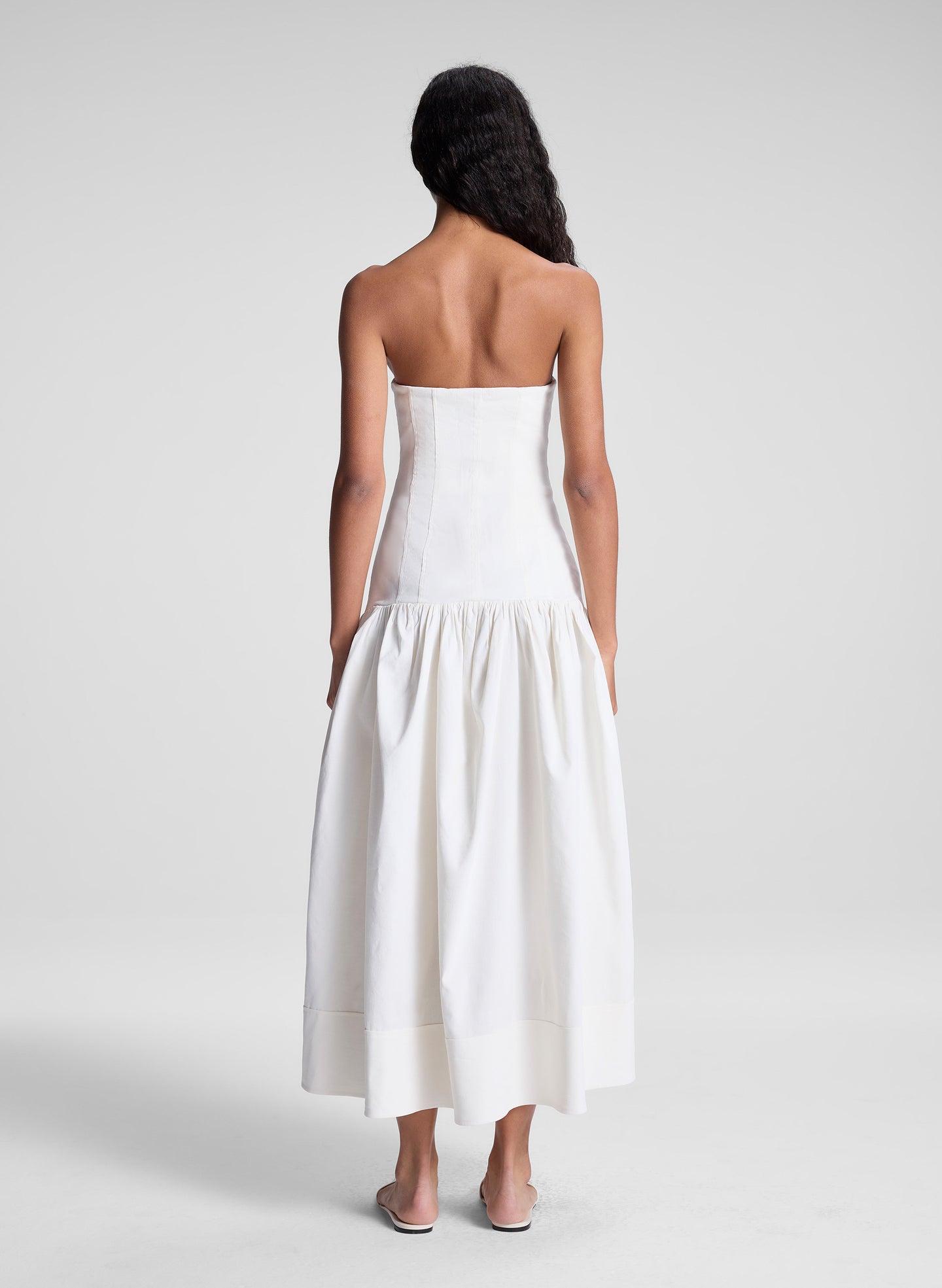 woman wearing white strapless drop waist midi dress