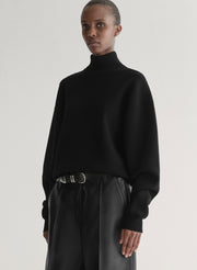 woman wearing black turtleneck sweater and black leather pants