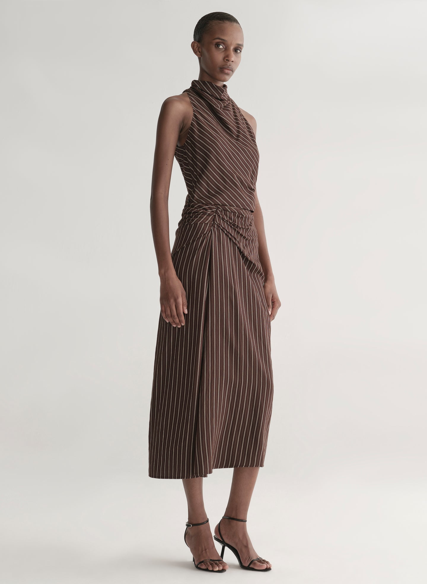 woman wearing brown striped top and matching midi skirt
