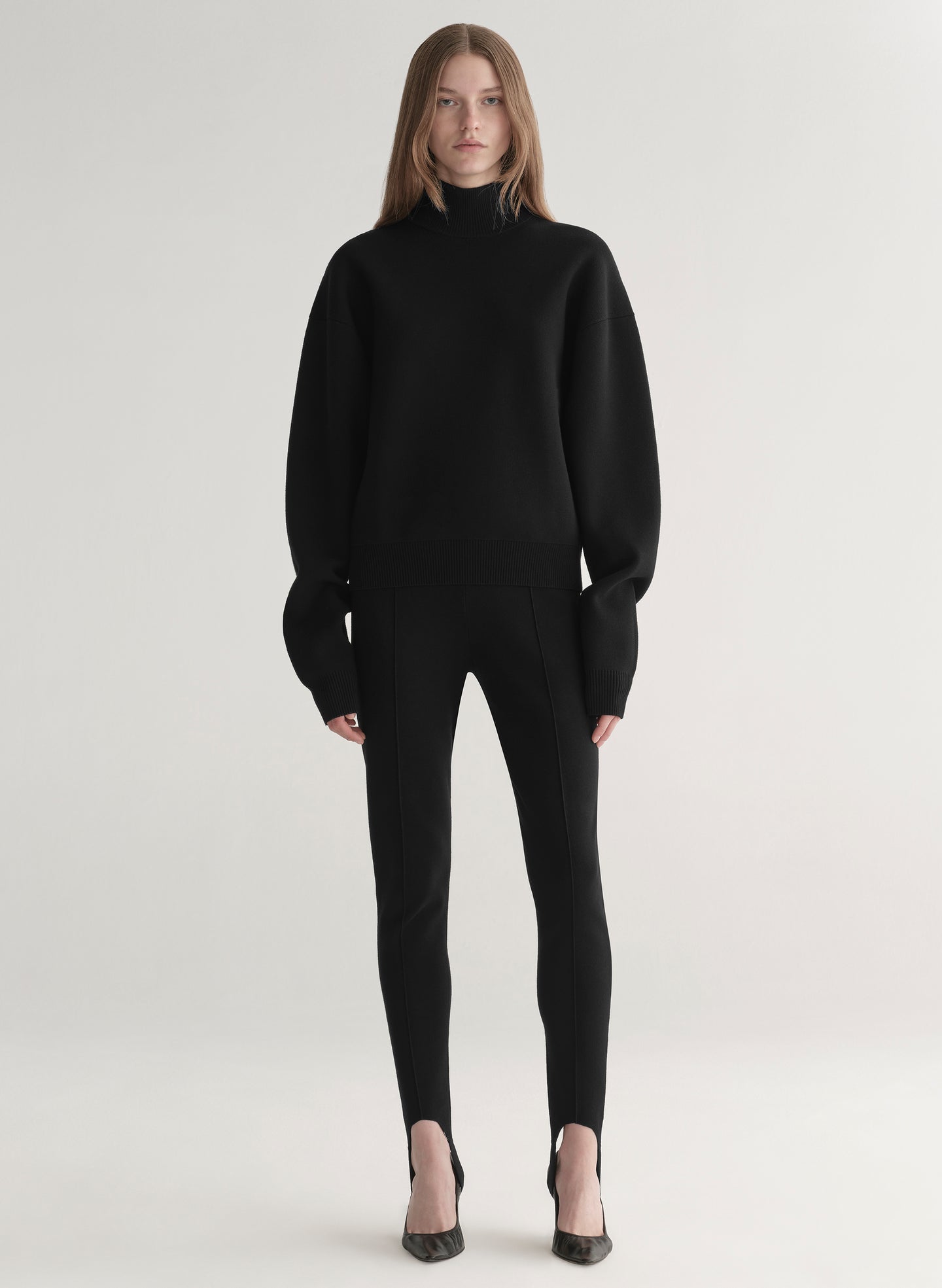 woman wearing black turtleneck sweater and black stirrup pants