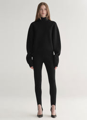 woman wearing black turtleneck sweater and black stirrup pants