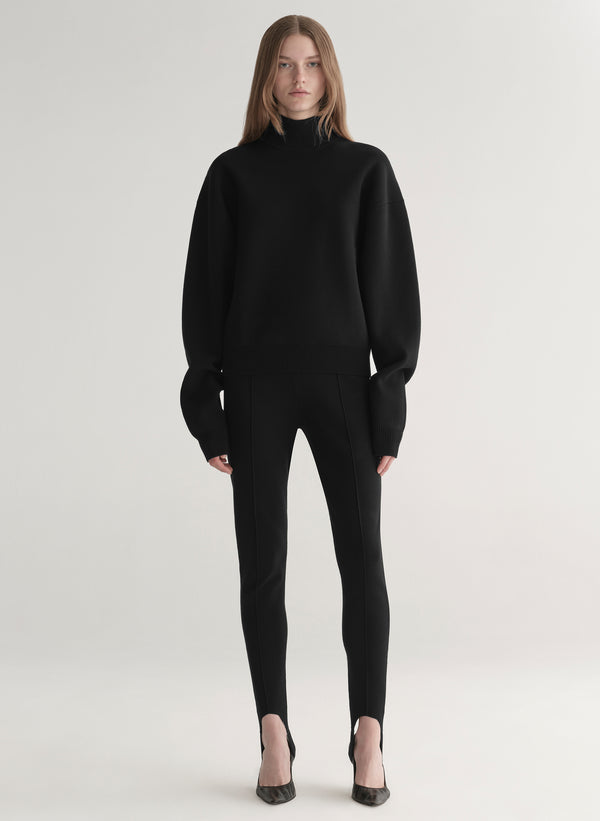 woman wearing black turtleneck sweater and black stirrup pants