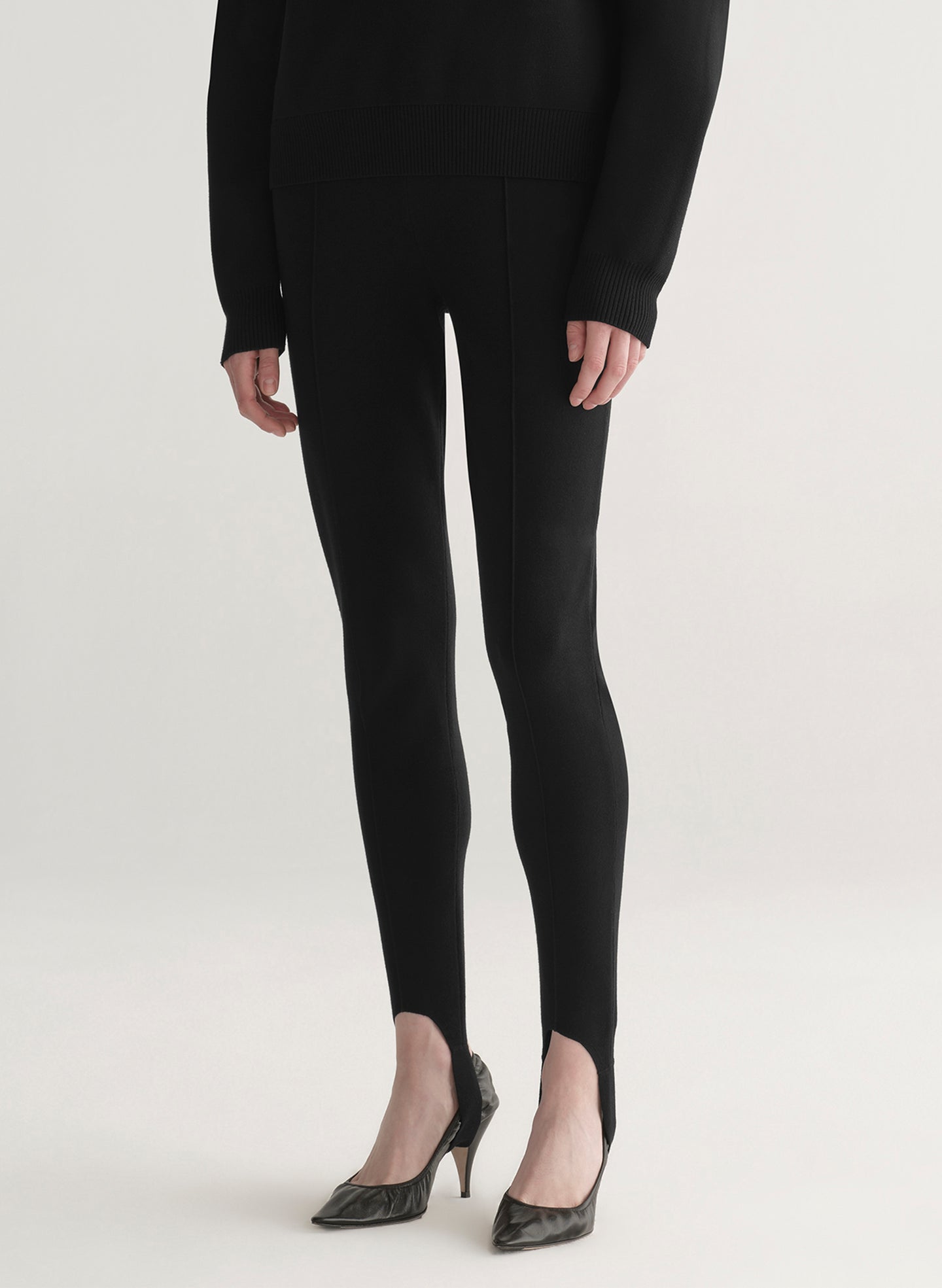 woman wearing black turtleneck sweater and black stirrup pants