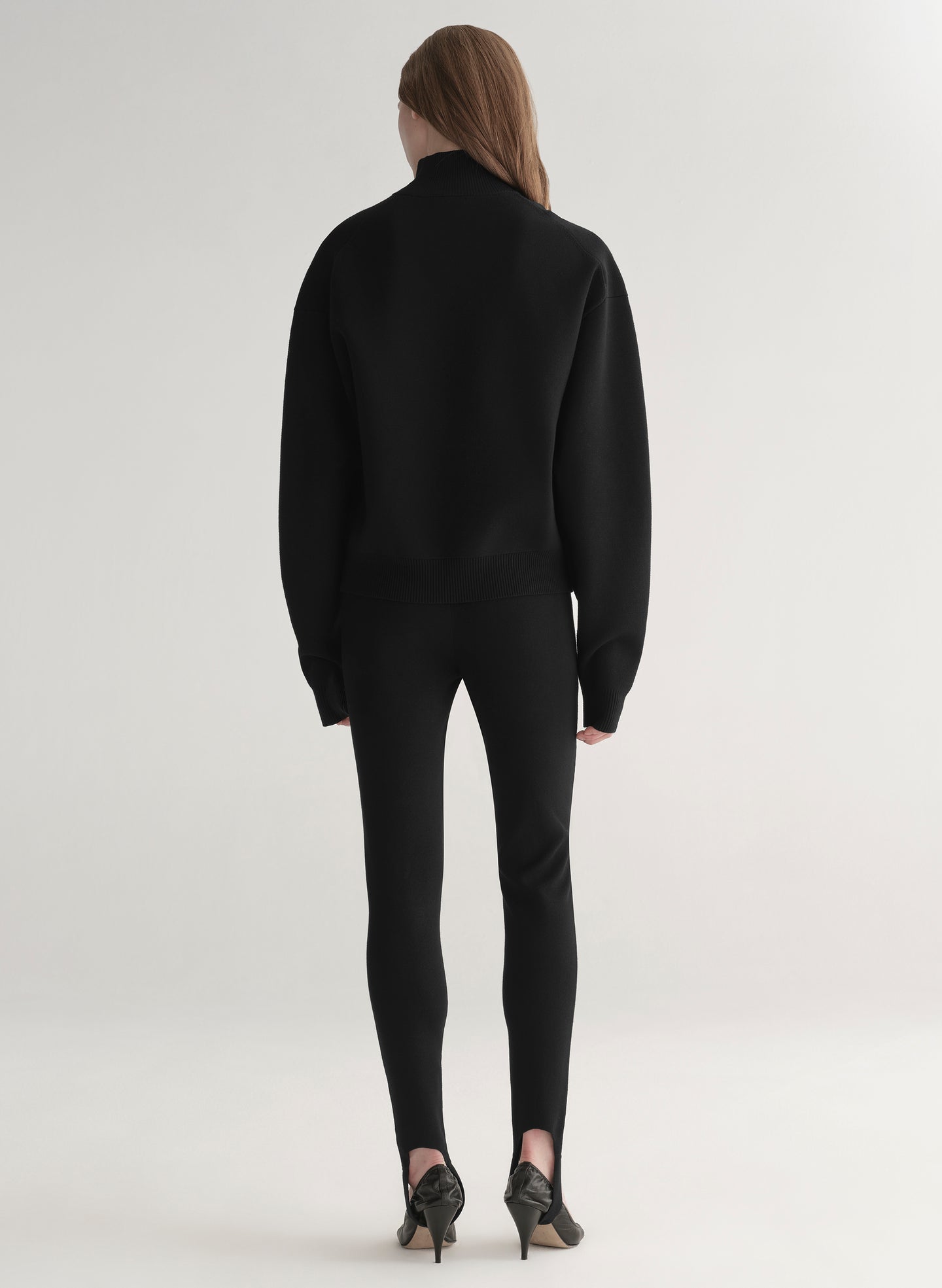 woman wearing black turtleneck sweater and black stirrup pants