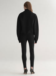 woman wearing black turtleneck sweater and black stirrup pants