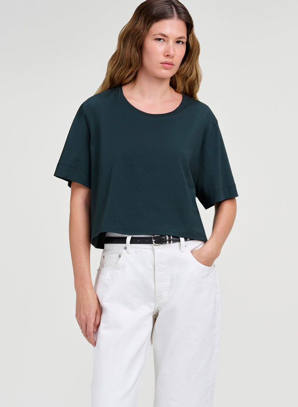 woman in green crop tee and white denim jeans
