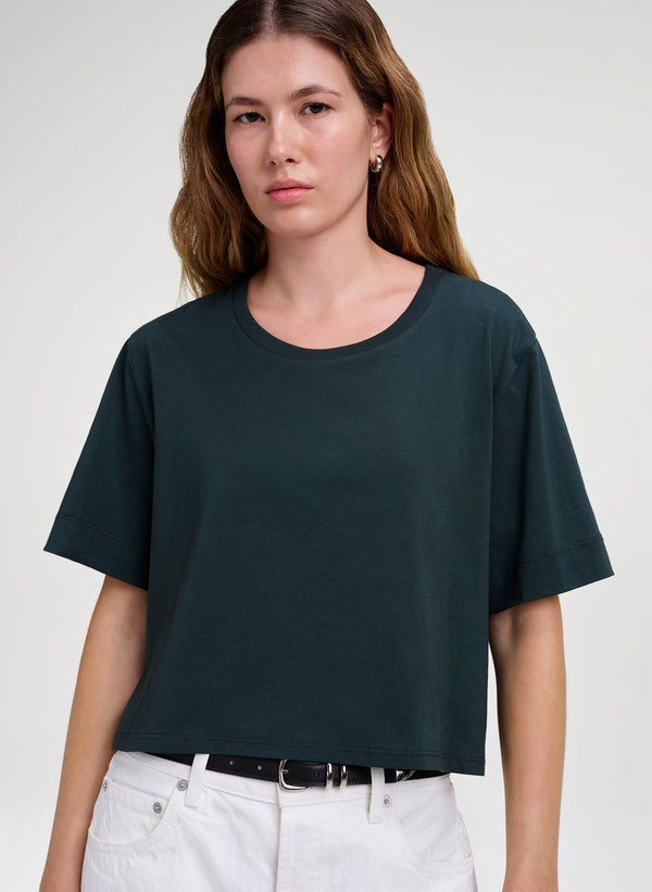 woman wearing green crop tee and white denim jeans