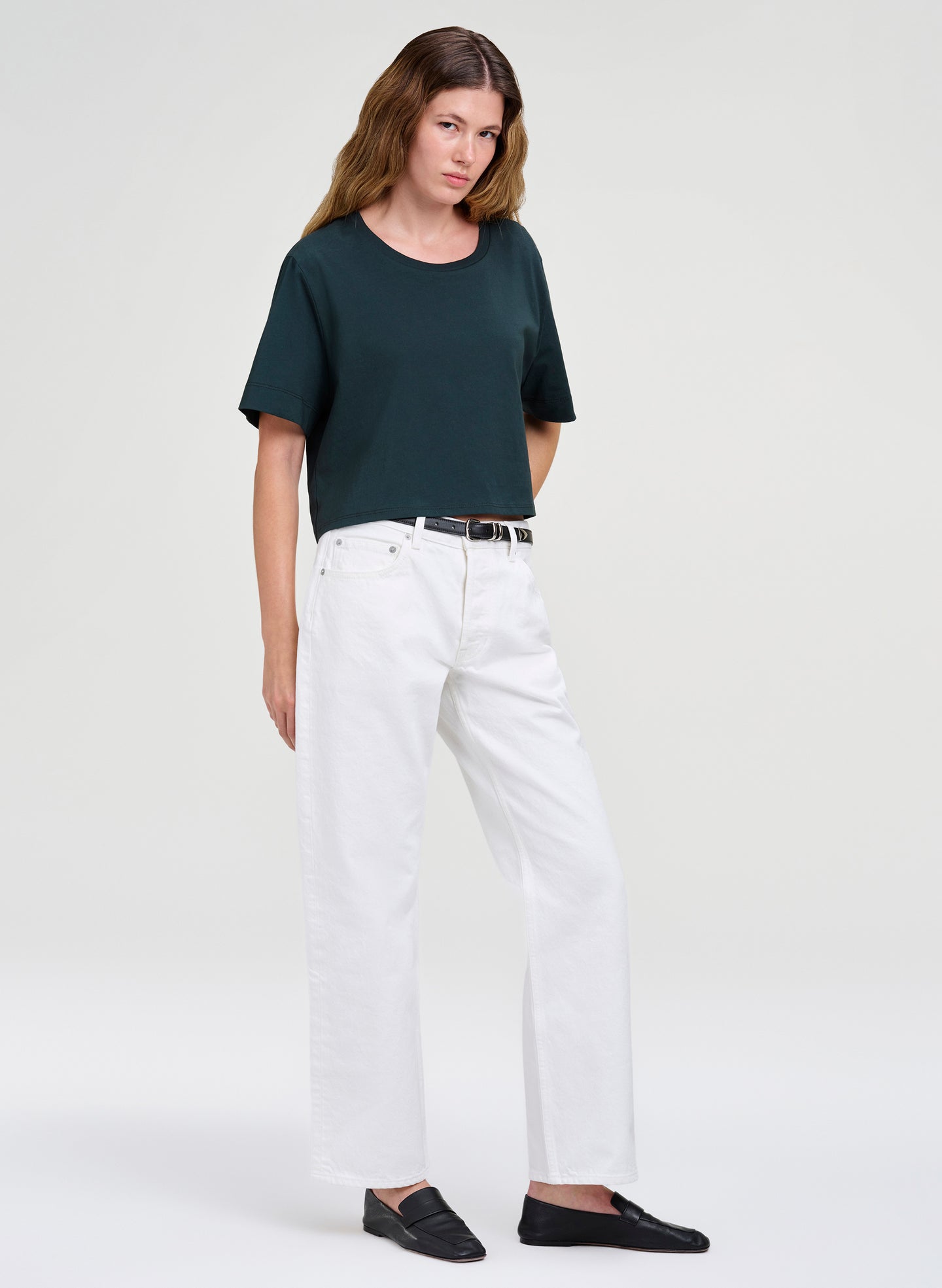 woman in dark green crop tee and white denim jeans