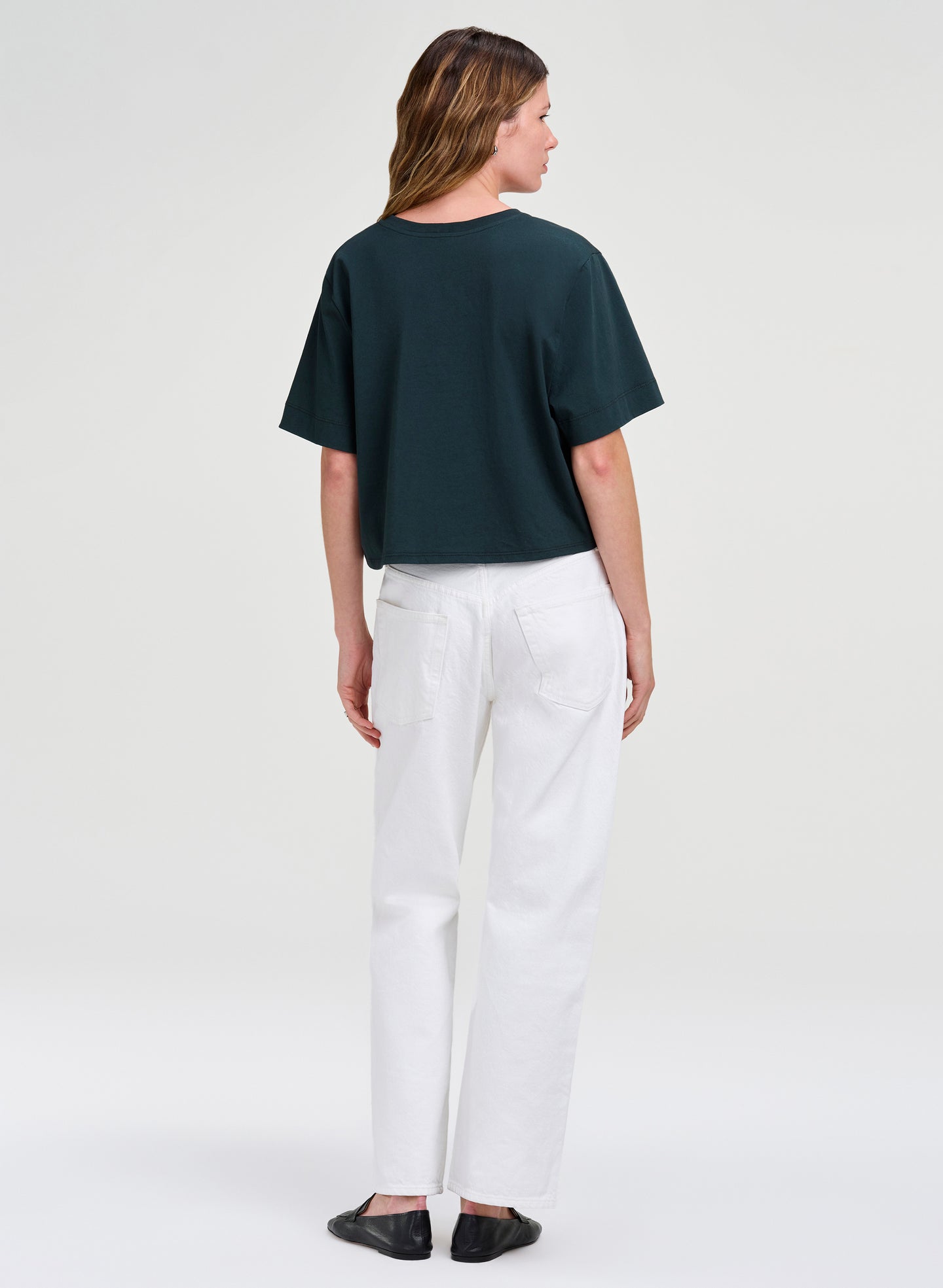 woman in green crop tee and white denim 