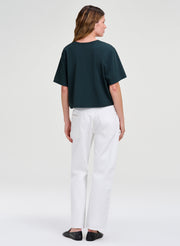 woman in green crop tee and white denim 
